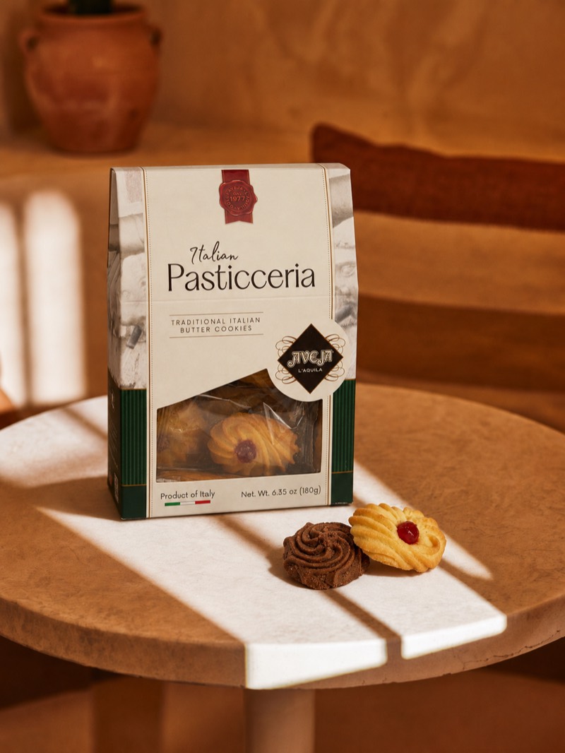 Generated scene — Pasticceria box on a travertine café table in golden light